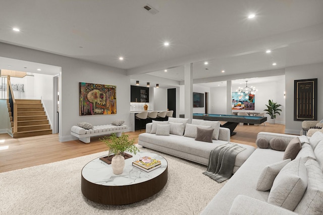 living room featuring a chandelier, light hardwood / wood-style floors, and billiards