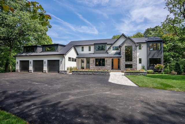 view of front of property featuring a garage and a front lawn