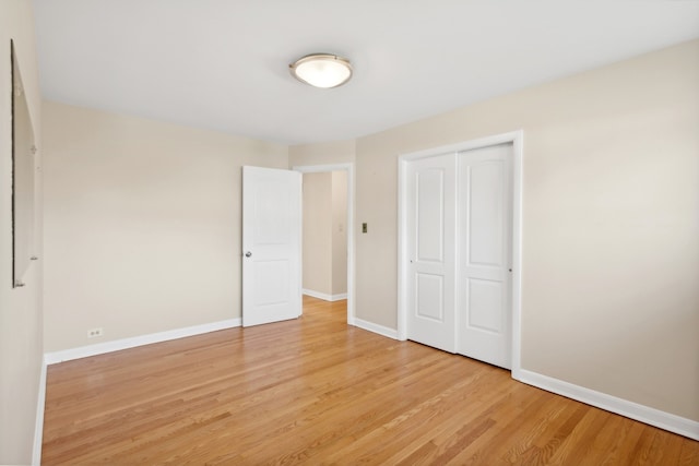 unfurnished bedroom featuring a closet and light hardwood / wood-style flooring