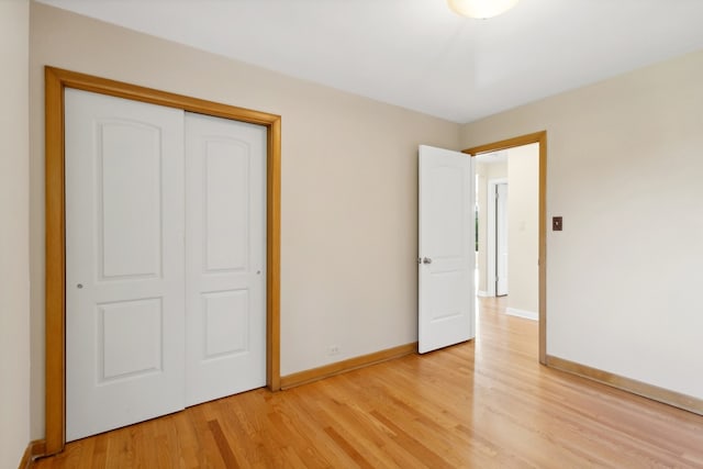 unfurnished bedroom with a closet and light hardwood / wood-style flooring