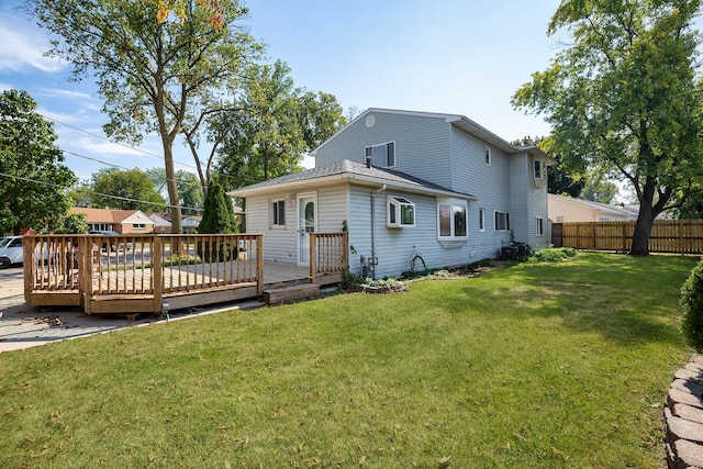 back of property with a wooden deck, a lawn, and central AC unit