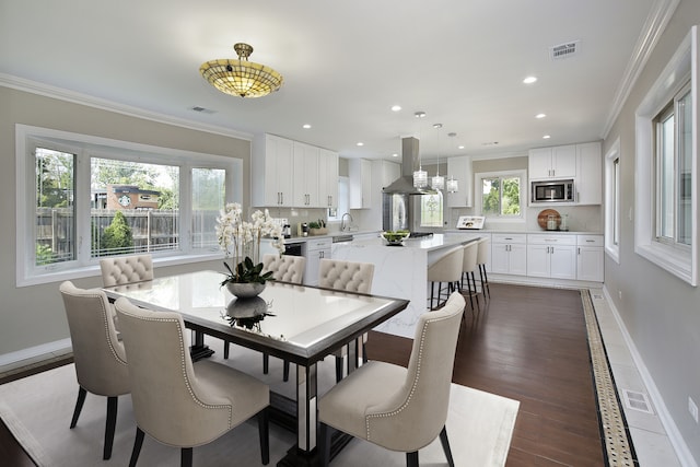 dining room featuring ornamental molding, dark wood-type flooring, and a wealth of natural light