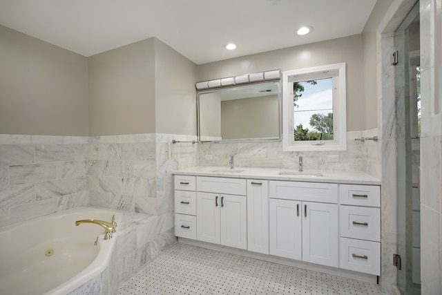 bathroom featuring tile walls, vanity, and shower with separate bathtub