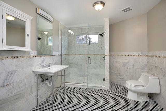 bathroom featuring tile walls, tile patterned floors, toilet, and an enclosed shower