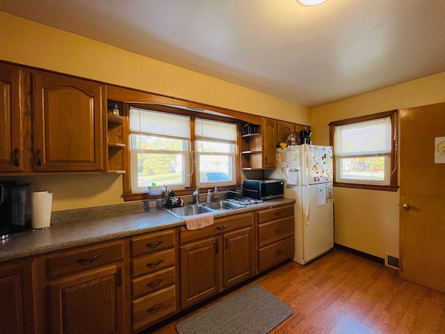 kitchen featuring sink, white fridge, and light hardwood / wood-style floors