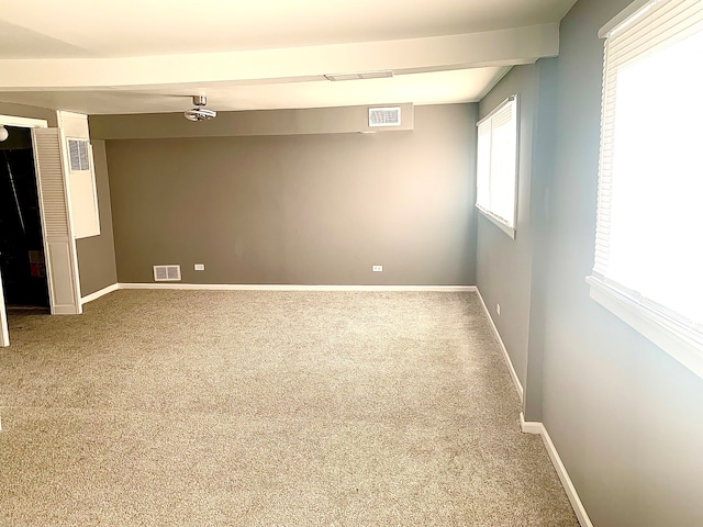 carpeted spare room with beamed ceiling