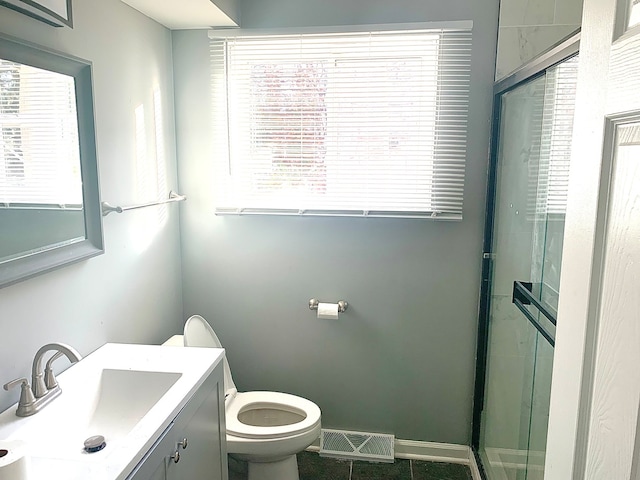 bathroom with vanity, tile patterned floors, toilet, and an enclosed shower