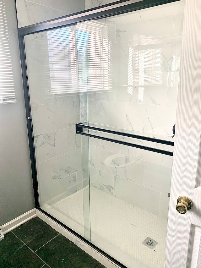 bathroom with a shower with shower door and tile patterned flooring