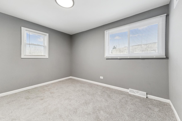 carpeted spare room featuring plenty of natural light