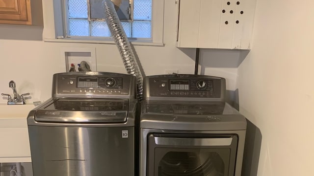 washroom featuring washing machine and dryer and cabinets