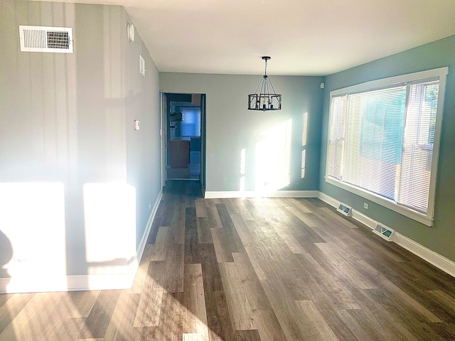 unfurnished dining area with hardwood / wood-style flooring and a chandelier