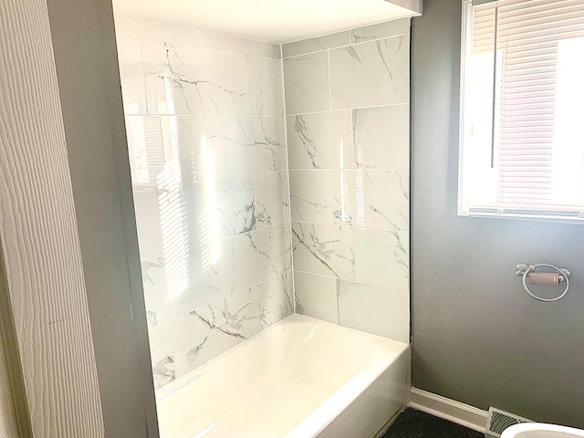 bathroom featuring tiled shower / bath