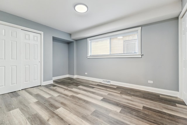 unfurnished bedroom featuring a closet and light hardwood / wood-style flooring