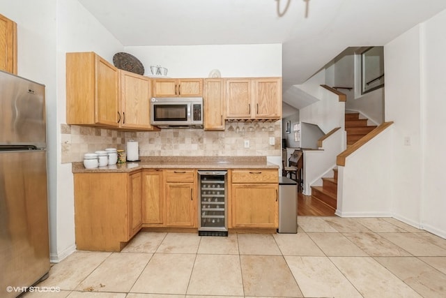 kitchen featuring wine cooler, tasteful backsplash, appliances with stainless steel finishes, and light tile patterned floors