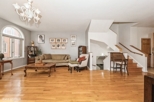 living room with light hardwood / wood-style flooring and an inviting chandelier