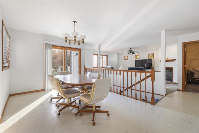 dining space with ceiling fan with notable chandelier