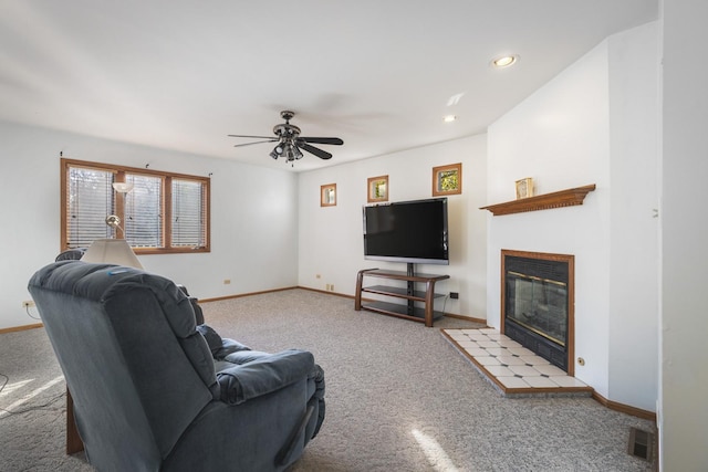 living room with light colored carpet, a fireplace, and ceiling fan