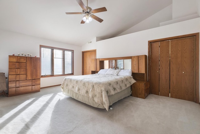 carpeted bedroom with multiple closets, high vaulted ceiling, and ceiling fan