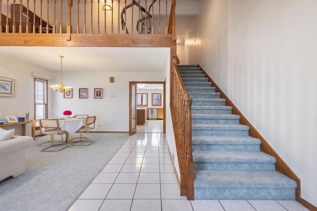 stairway with a chandelier, carpet, and a high ceiling