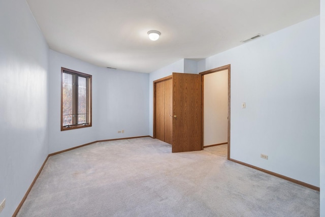 unfurnished bedroom with light carpet and a closet