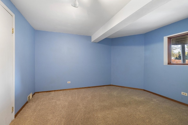 unfurnished room featuring light carpet and beamed ceiling