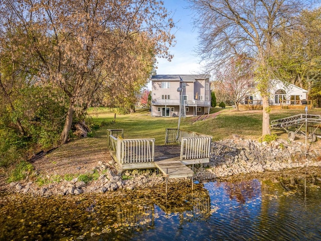 back of property with a yard and a water view