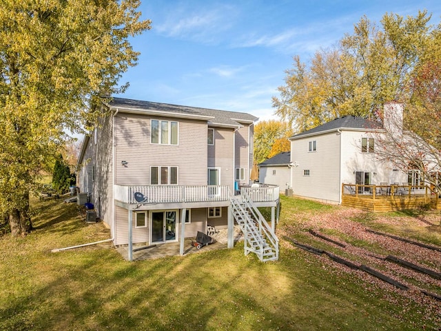 back of house featuring a wooden deck, central air condition unit, and a lawn