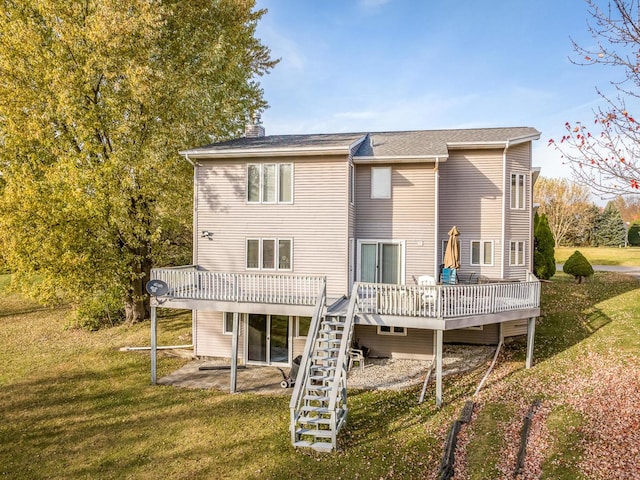 rear view of property featuring a deck and a lawn