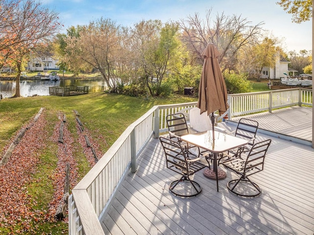 deck with a water view and a lawn