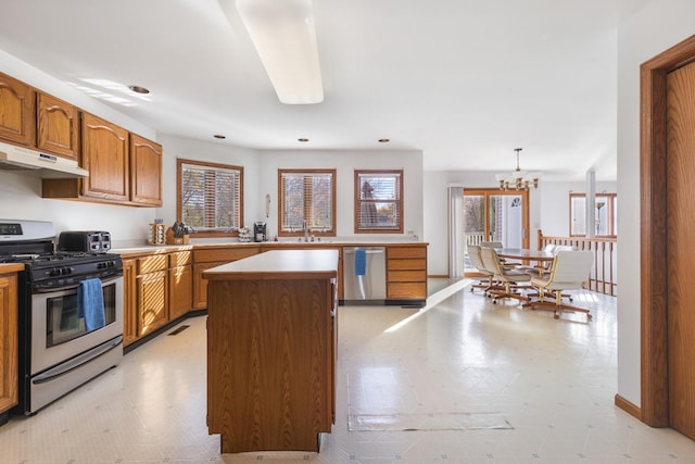 kitchen with pendant lighting, a center island, a notable chandelier, and stainless steel appliances