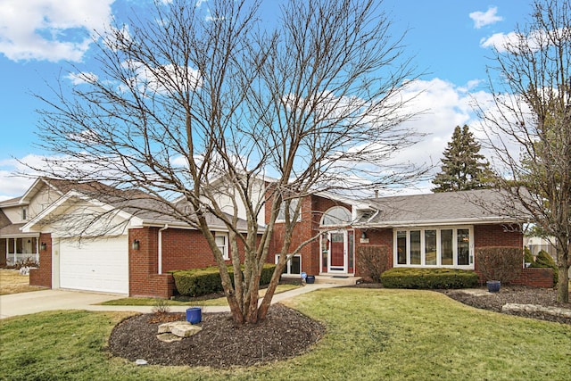 tri-level home featuring a garage, driveway, brick siding, and a front lawn