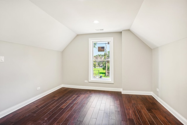 additional living space featuring lofted ceiling and dark wood-type flooring