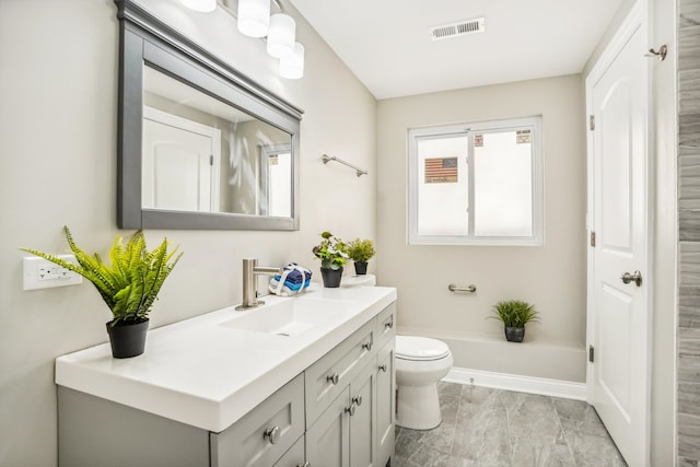 bathroom with vanity, toilet, and a bath