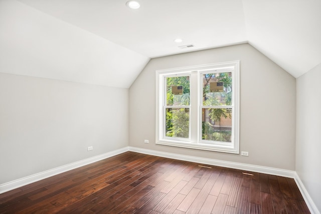 bonus room with dark wood-type flooring and vaulted ceiling