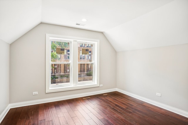 additional living space with hardwood / wood-style flooring and vaulted ceiling