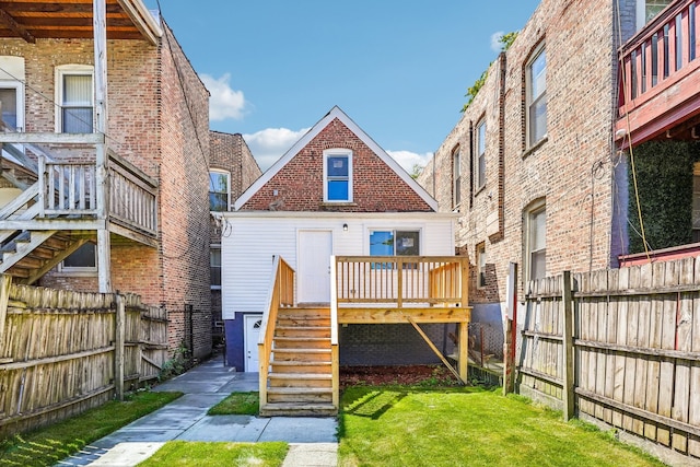 back of property featuring a deck and a yard