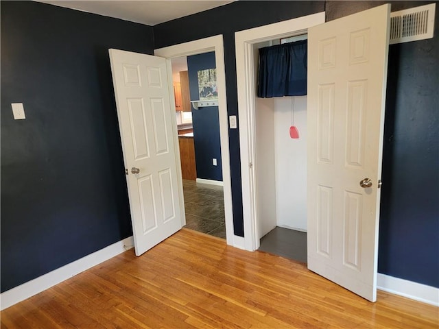 unfurnished bedroom featuring a closet and hardwood / wood-style floors