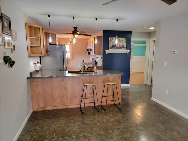 kitchen featuring kitchen peninsula, stainless steel fridge, decorative light fixtures, and ceiling fan