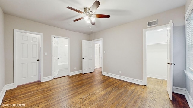 unfurnished bedroom with ceiling fan, connected bathroom, and dark hardwood / wood-style floors