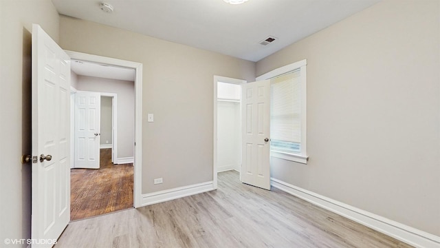 unfurnished bedroom featuring light hardwood / wood-style flooring and a closet