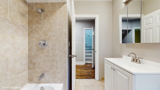 bathroom featuring tiled shower / bath combo, tile patterned floors, and vanity