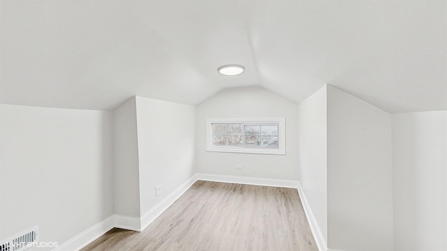 additional living space featuring light hardwood / wood-style floors and lofted ceiling