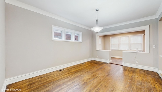 unfurnished dining area with hardwood / wood-style flooring and ornamental molding