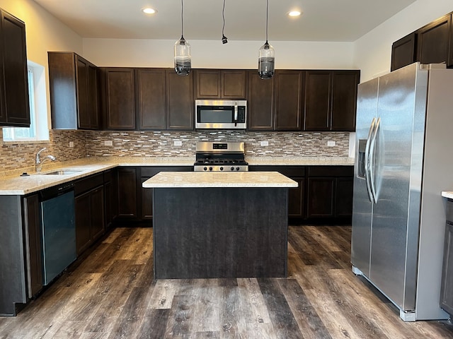 kitchen featuring appliances with stainless steel finishes, a center island, hanging light fixtures, and dark hardwood / wood-style flooring