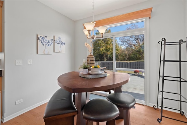 dining room featuring light wood-type flooring and a notable chandelier