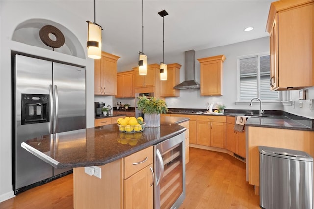 kitchen featuring light wood-type flooring, beverage cooler, wall chimney range hood, stainless steel fridge with ice dispenser, and a center island