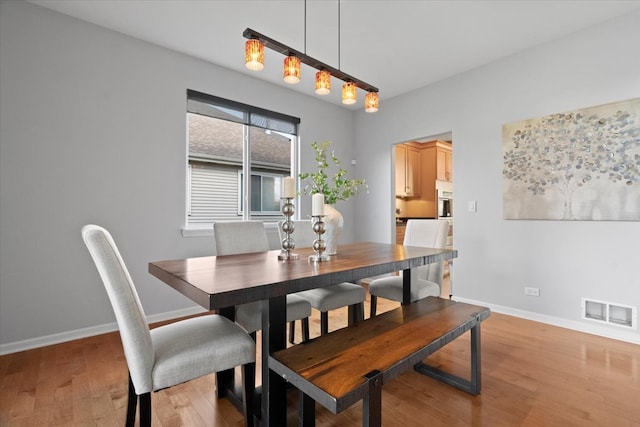 dining space with light hardwood / wood-style floors and rail lighting