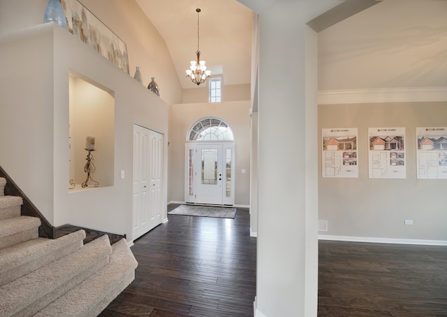 foyer featuring high vaulted ceiling, dark hardwood / wood-style floors, and an inviting chandelier