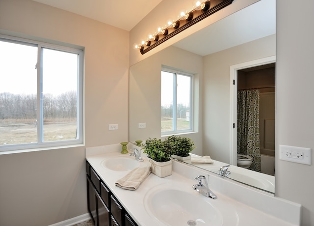 bathroom featuring vanity, toilet, and plenty of natural light