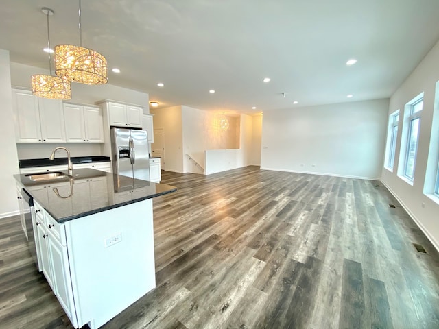 kitchen featuring a center island with sink, sink, pendant lighting, white cabinetry, and appliances with stainless steel finishes